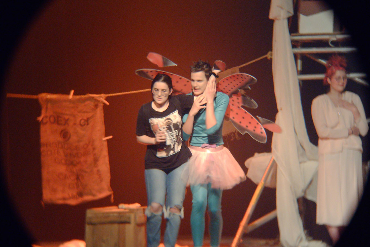 Sur scène deux acteurs se donnent la réplique, l'un deux porte des ailes de papillon et un tutu
