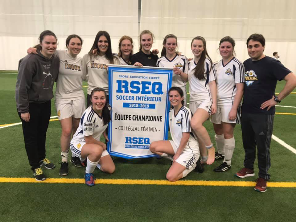 L'équipe féminine de soccer intérieur avec la grande bannière de championnat du RSEQ