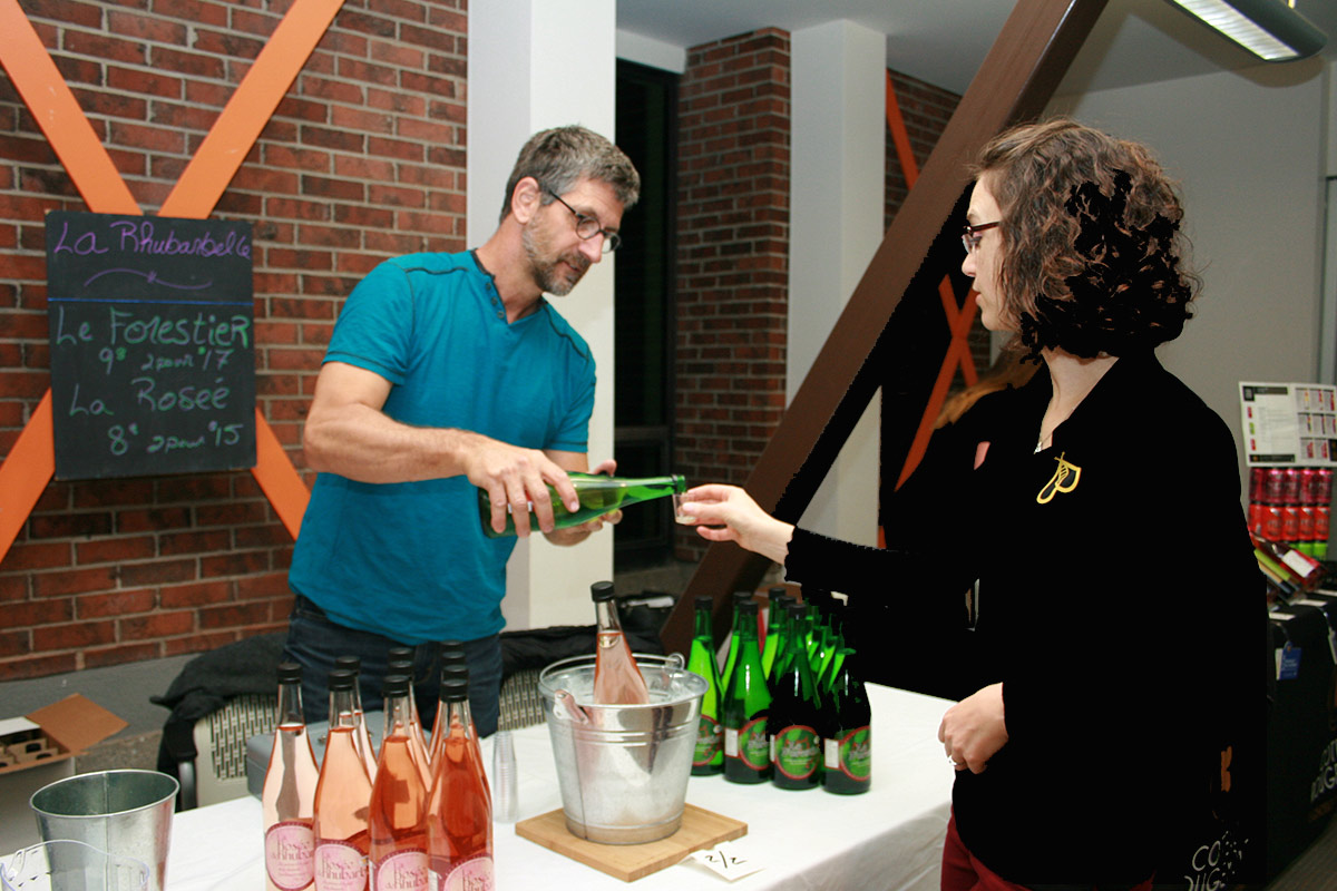 Un homme verse une coupe de vin à une femme dans un kiosque de la Foire des vins