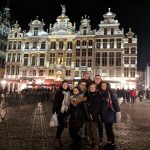 Groupe d'étudiant d'Éducation spécialisée devant un bâtiment historique en Belgique la nuit