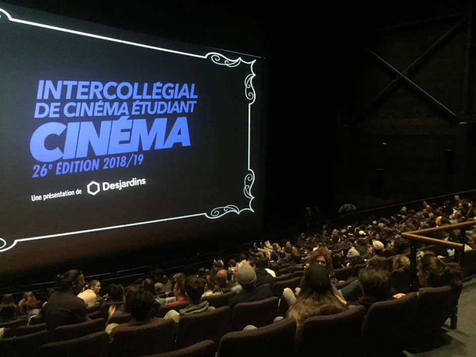 Salle de spectacle avec un écran où figure : Intercollégial de cinéma étudiant, cinéma 26e édition 2018/19. une présentation de Desjardins