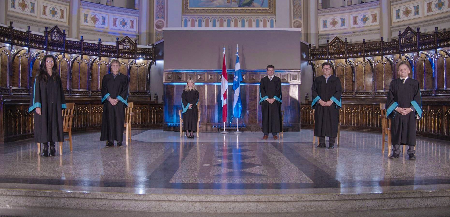 Six dignitaires en toge debout sur l'estrade pour la remise des diplômes au pavillon Notre-Dame