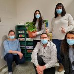 Cinq membre des comités environnementaux devant les étagères de partage de semences