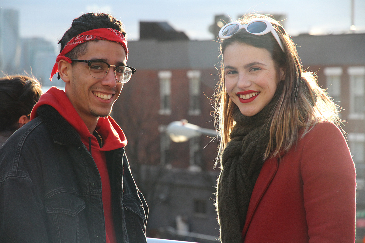 Photo d'un étudiant et étudiante qui sourient avec édifice à New York en arrière plan.