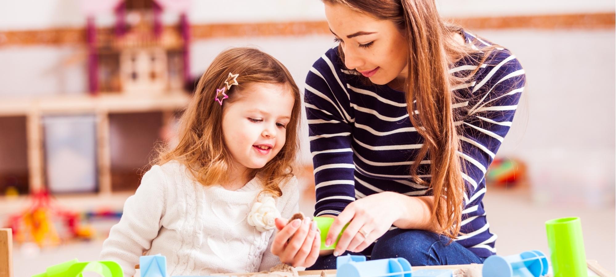 Une jeune femme avec une fillette dans une garderie