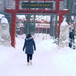 Jeune femme de dos marchant dans la neige vers le pavillon chinois