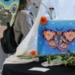 Exposition de peinture, à l'avant une toile avec un papillon