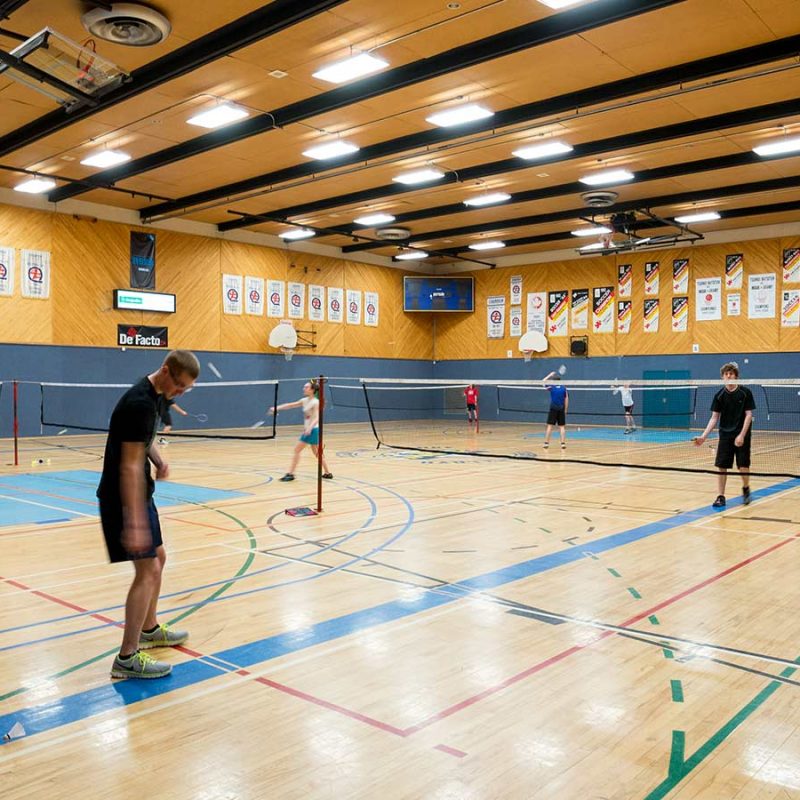 gymnase du cégep avec des gens pratiquant le badminton