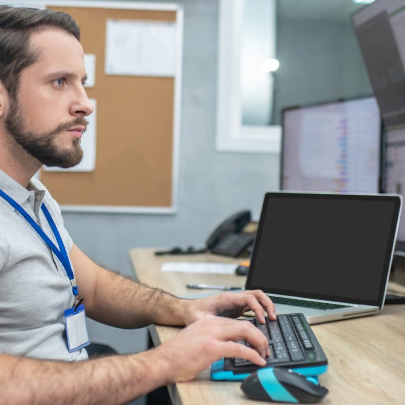 Un homme tape au clavier devant un ordinateur