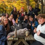 Groupe d'étudiants assis à une table de pique-nique en automne