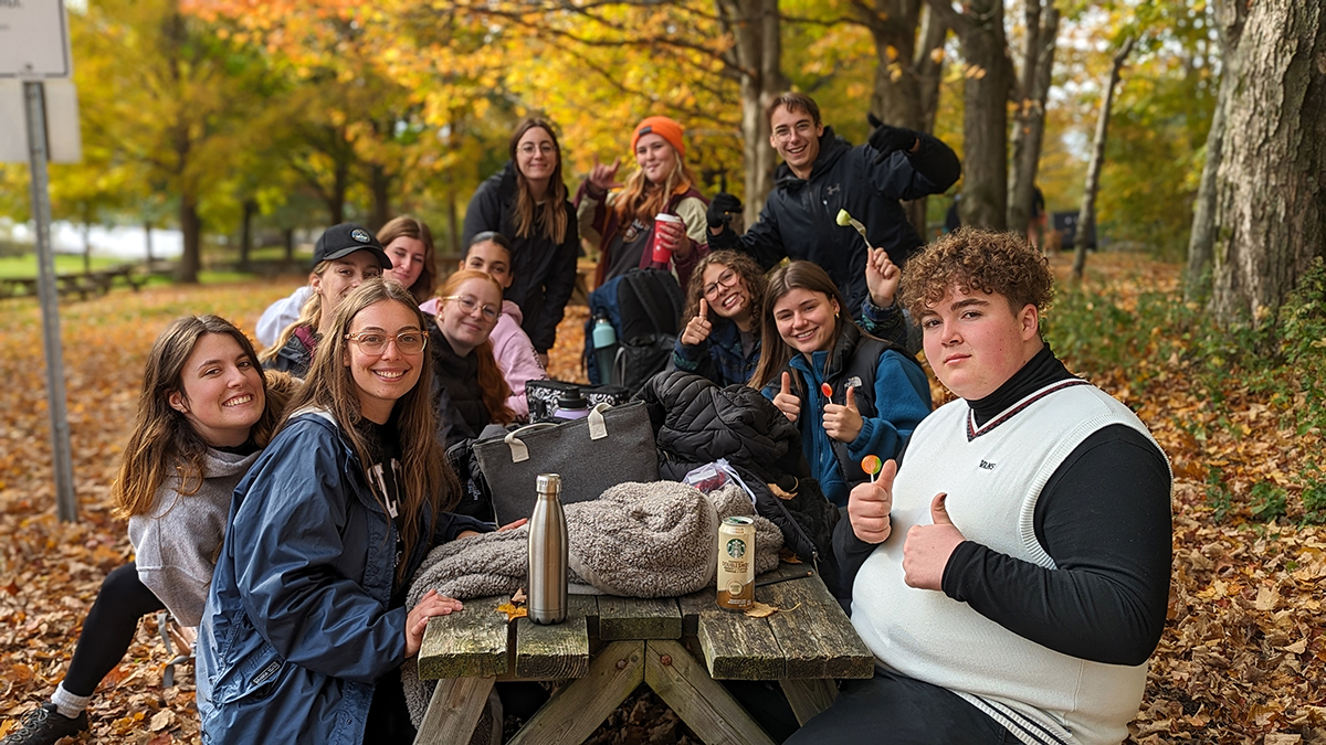 Groupe d'étudiants assis à une table de pique-nique en automne