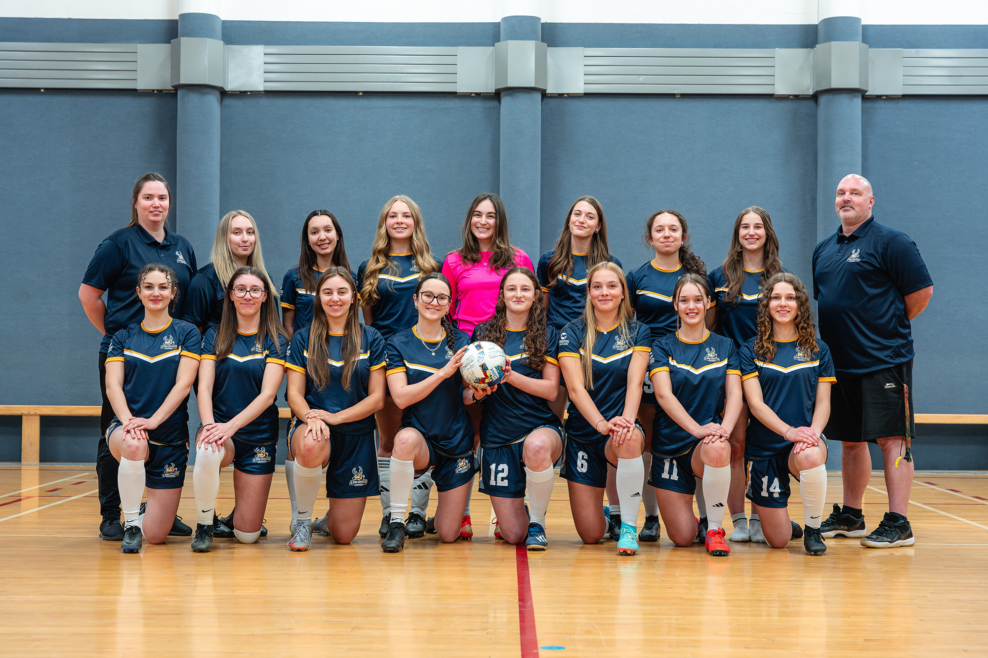 Équipe de soccer intérieur féminin et entraîneurs en uniforme
