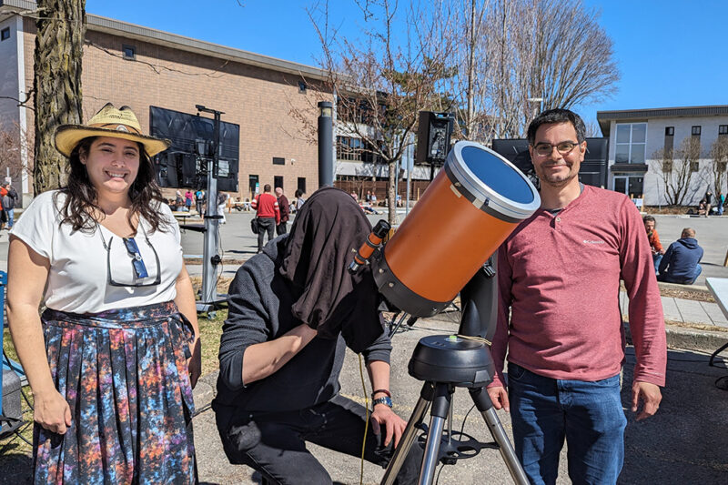Trois personnes à l'extérieur avec un téléscope