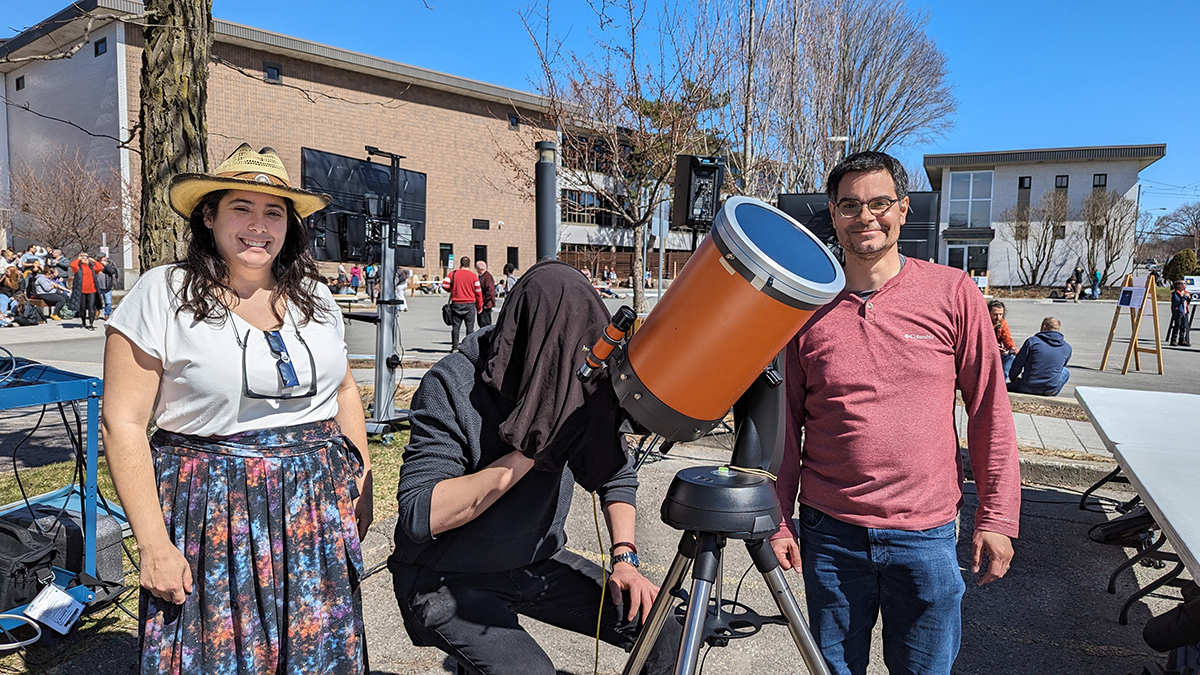 Trois personnes à l'extérieur avec un téléscope