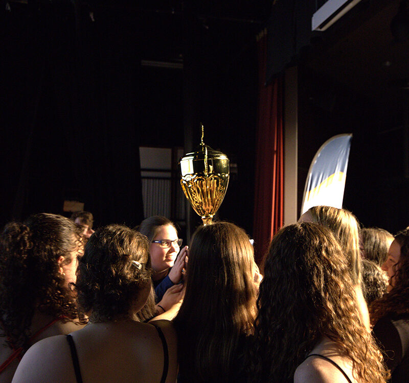 Un groupe de jeunes femmes tiennent un trophée dans les airs