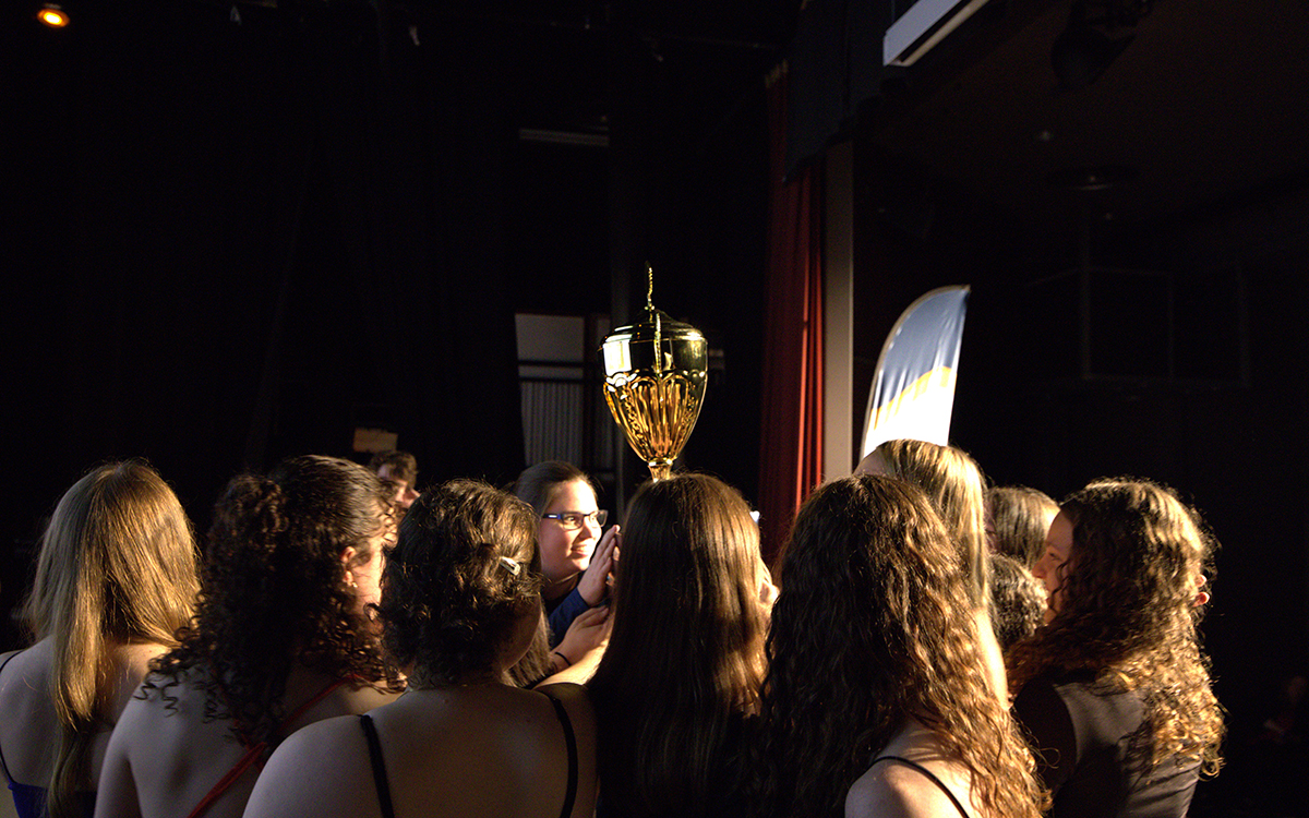 Un groupe de jeunes femmes tiennent un trophée dans les airs