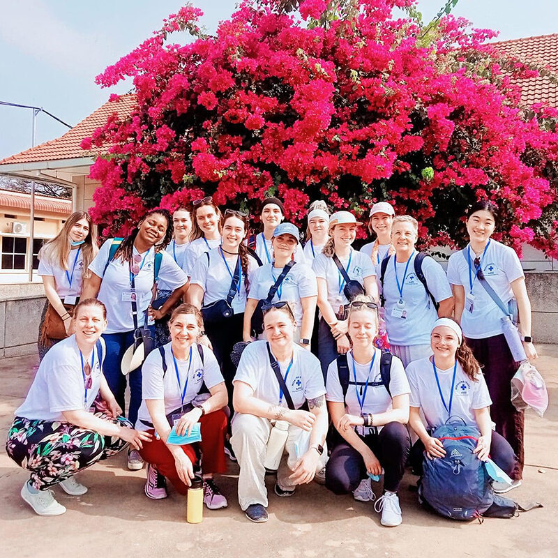 Groupe d'infirmières devant un arbre fleuri au Cambodge