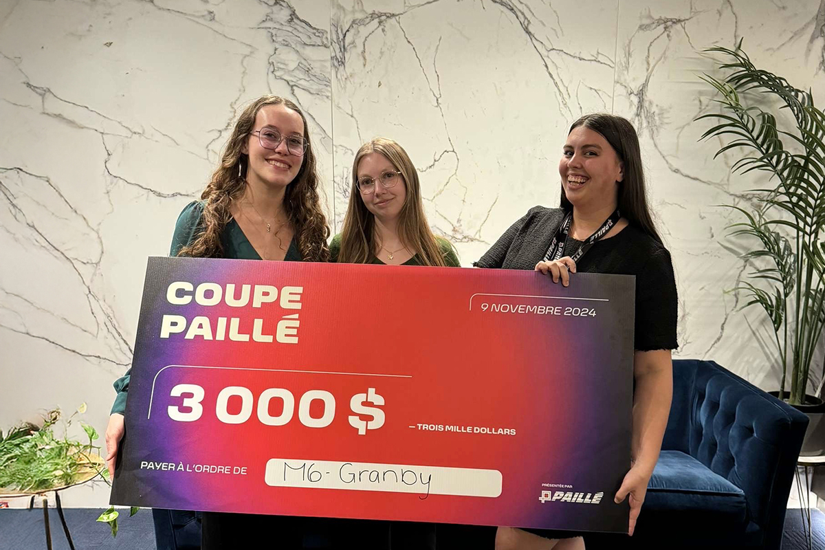 Trois étudiantes tiennent un gros chèque de 3 000 $ indiquant Coupe Paillé.