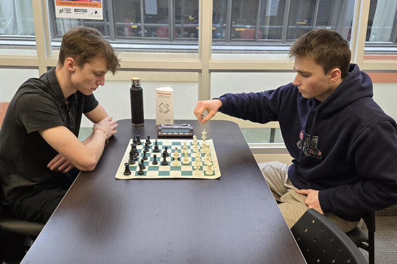 Deux jeunes hommes jouent aux échecs