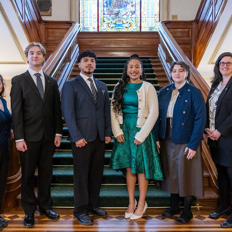 Six personnes en tenue de ville au pied de l'escalier à l'Assemblée nationale du Québec