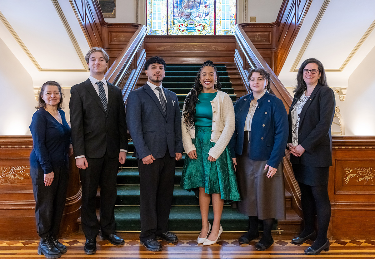 Six personnes en tenue de ville au pied de l'escalier à l'Assemblée nationale du Québec