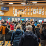 Vue d'un gymnase transformé en salon avec une foule de visiteurs