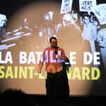 Un homme au micro avec le titre La bataille de Saint-Léonard