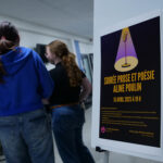 Des jeunes filles discutent à côté de l'affiche Soirée Prose et poésie