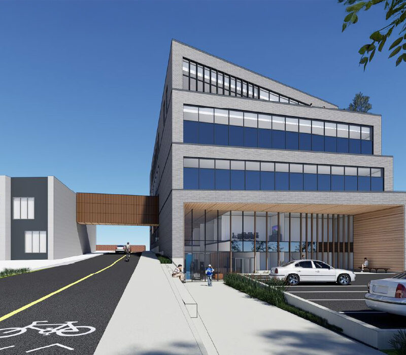 Vue d'un bâtiment avec un stationnement et une piste cyclabe