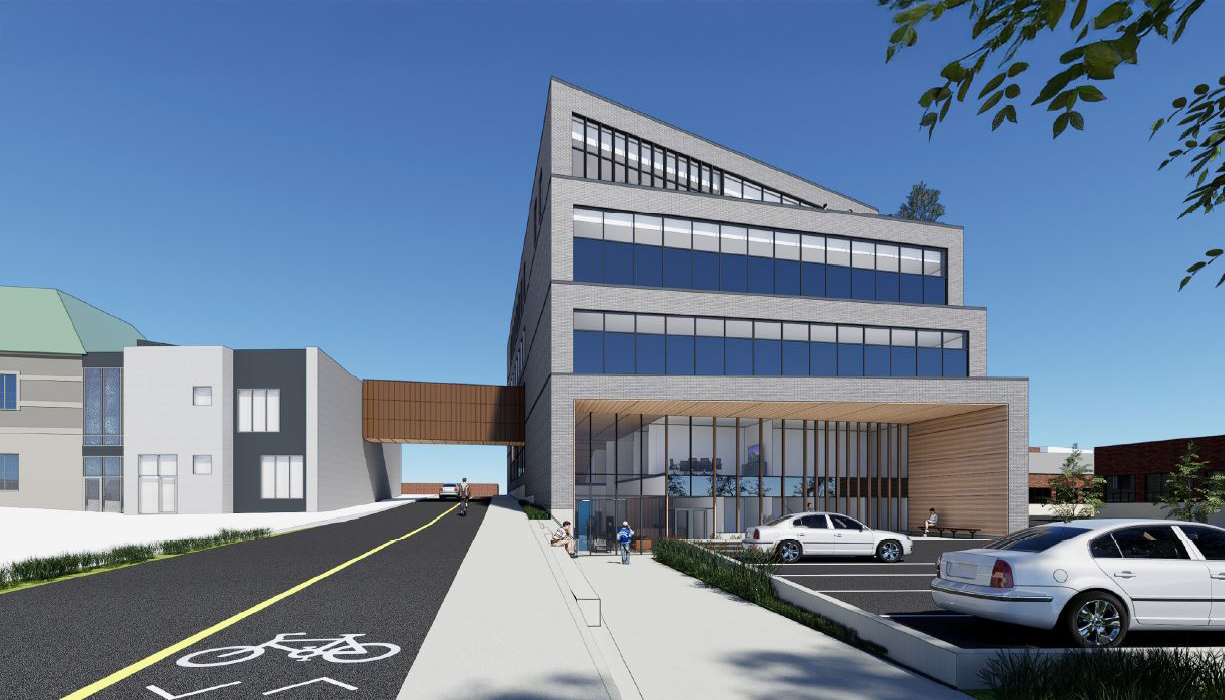 Vue d'un bâtiment avec un stationnement et une piste cyclabe