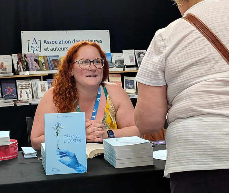 Une autrice à son kiosque dans un salon du livre