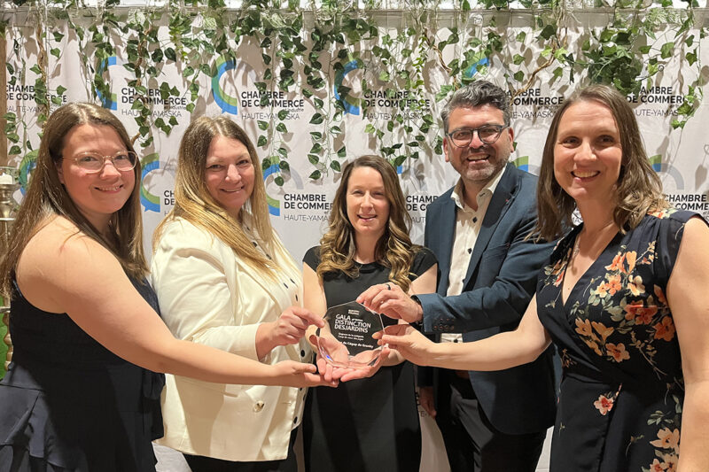 Quatre femmes et un homme tenant un trophée