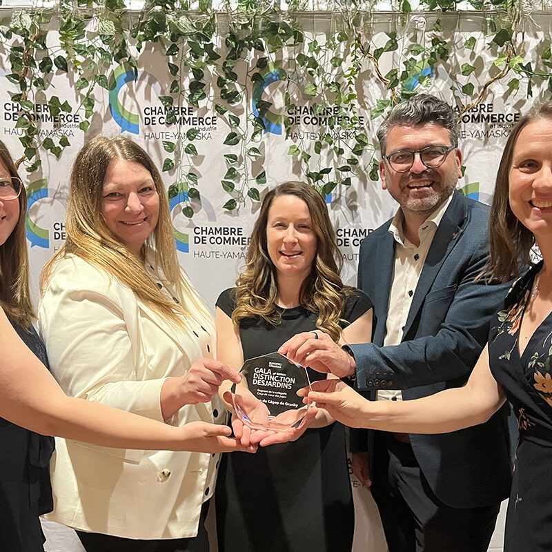 Quatre femmes et un homme tenant un trophée