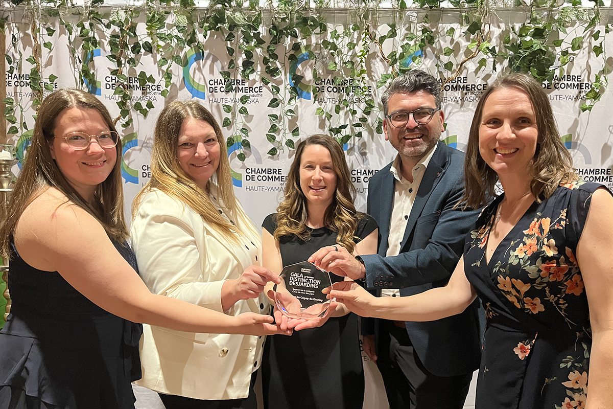 Quatre femmes et un homme tenant un trophée