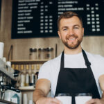 Un barista tient deux cafés dans ses mains