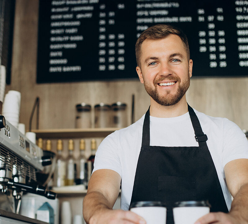 Un barista tient deux cafés dans ses mains