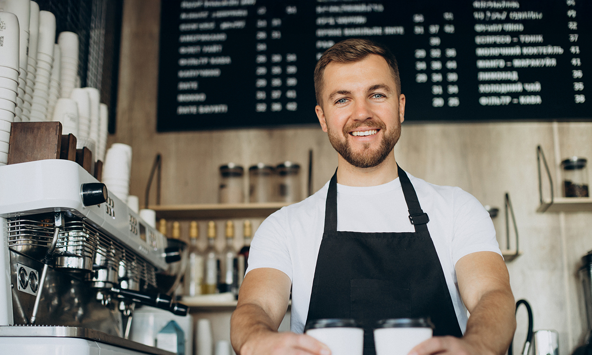 Un barista tient deux cafés dans ses mains