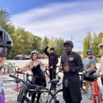 Six cyclistes sur une piste cyclable entourée d'arbres