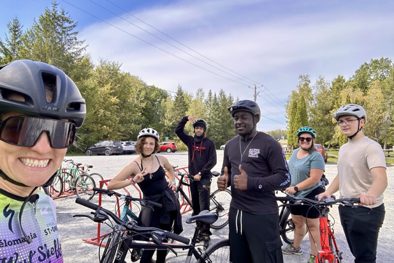 Six cyclistes sur une piste cyclable entourée d'arbres