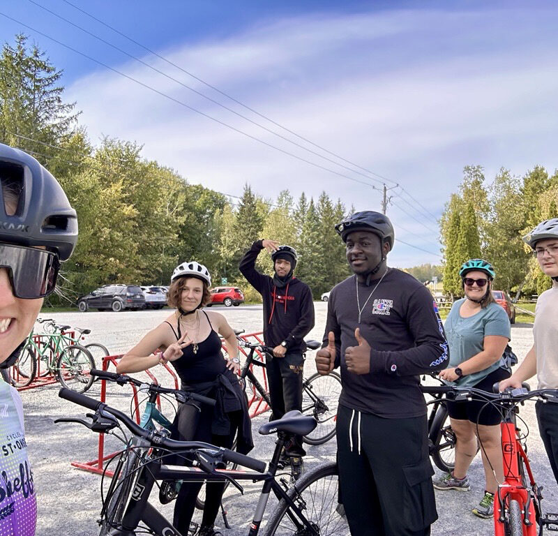 Six cyclistes sur une piste cyclable entourée d'arbres