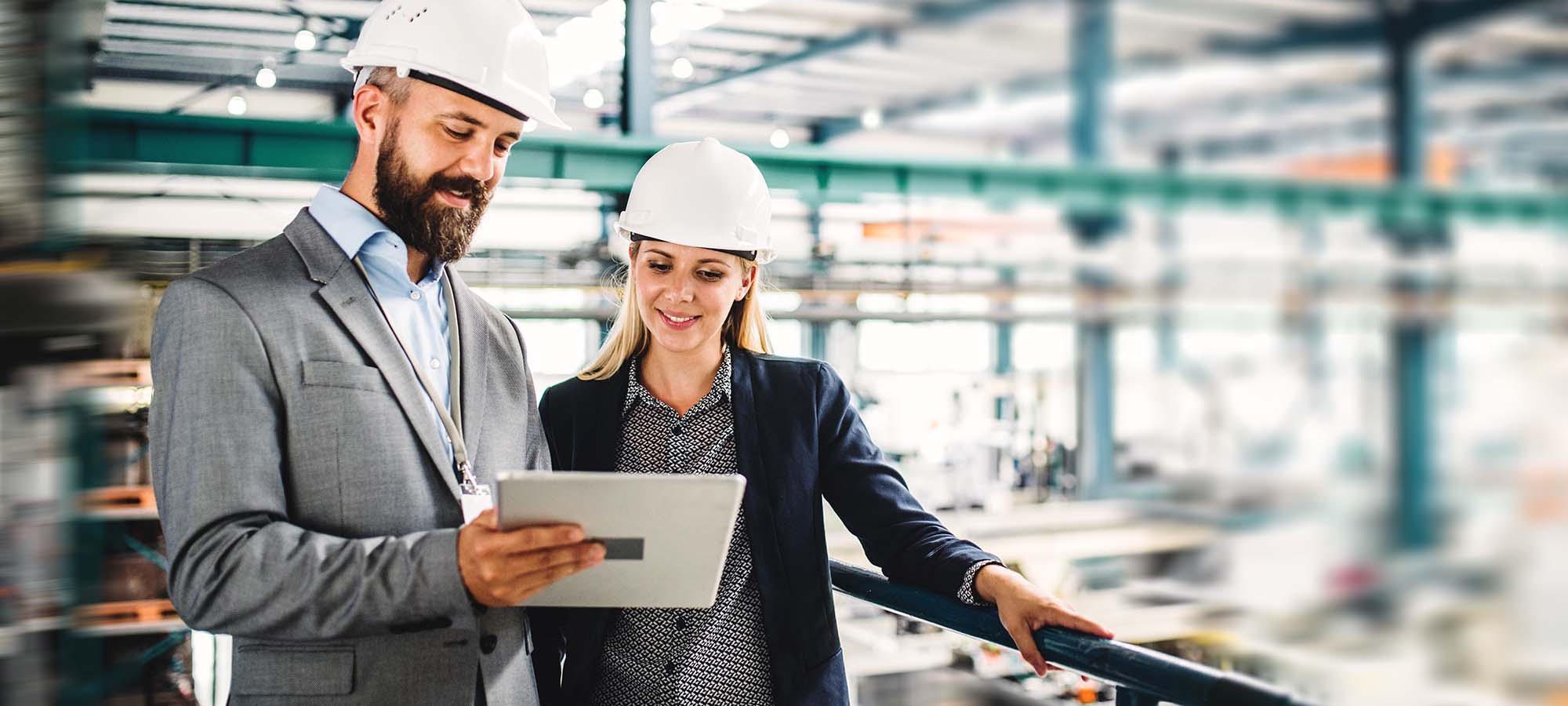 Un homme et une femme avec des casques blancs dans une usine