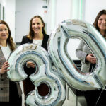 Trois femmes tenant des ballons indiquant 30.