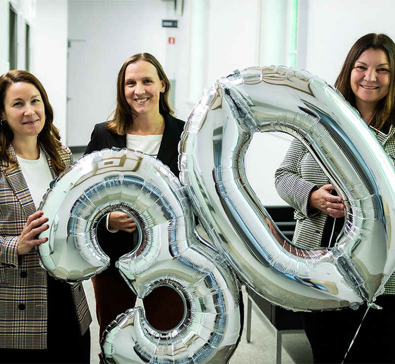 Trois femmes tenant des ballons indiquant 30.