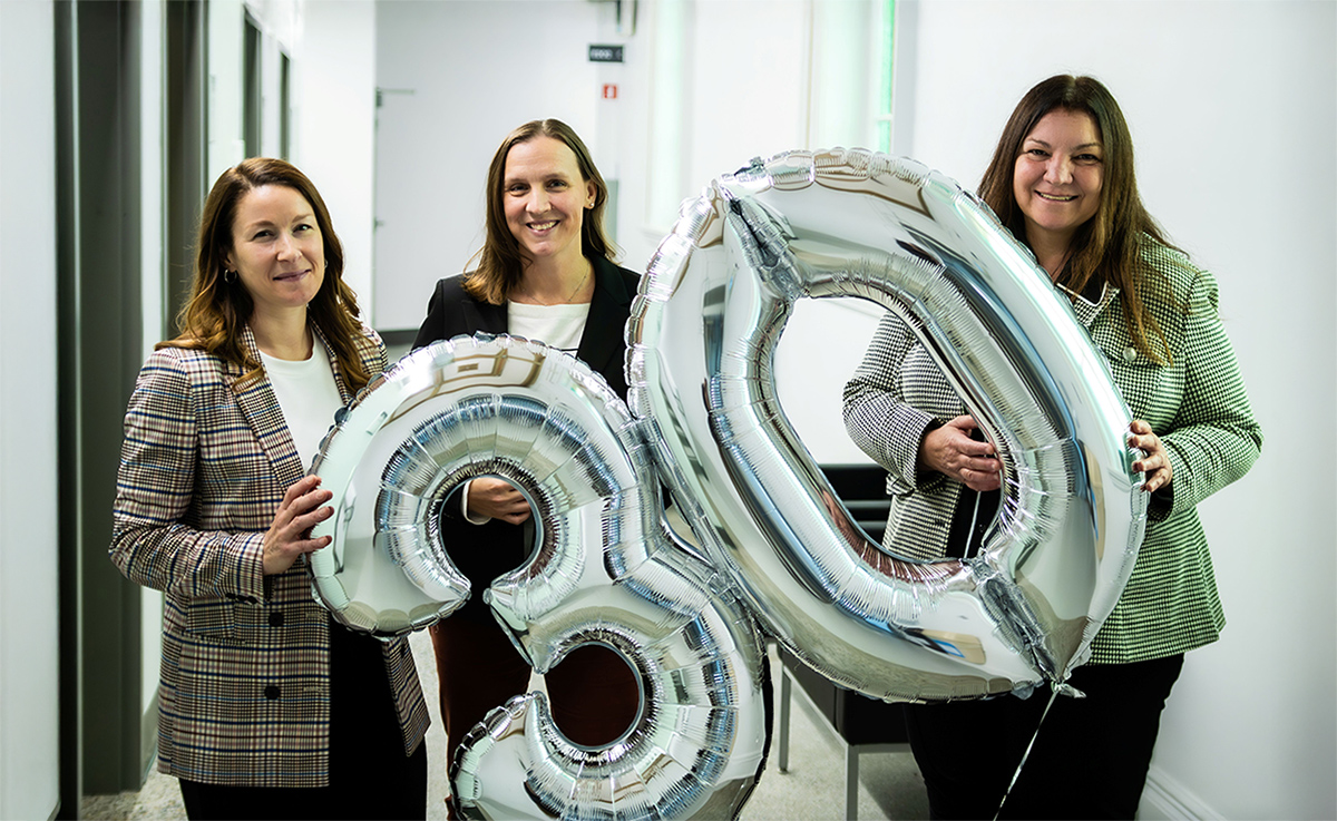 Trois femmes tenant des ballons indiquant 30.
