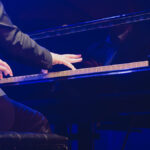 Vue de dos d'un pianiste en action sous les projecteurs