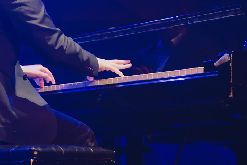 Vue de dos d'un pianiste en action sous les projecteurs