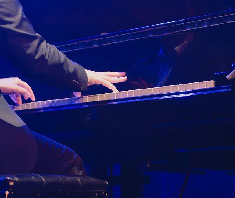 Vue de dos d'un pianiste en action sous les projecteurs