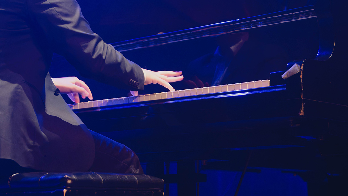 Vue de dos d'un pianiste en action sous les projecteurs