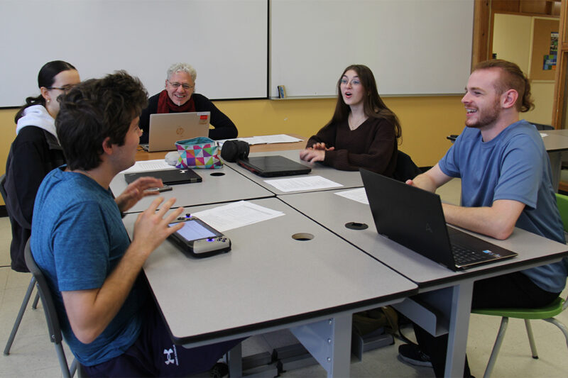 Quatre étudiants et un enseignant dans un groupe de travail en classe