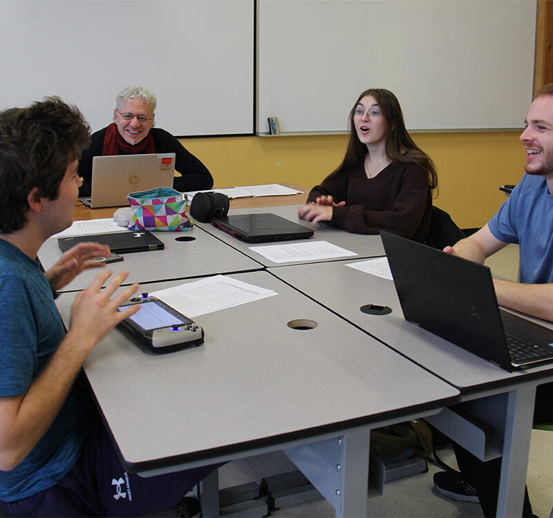 Quatre étudiants et un enseignant dans un groupe de travail en classe